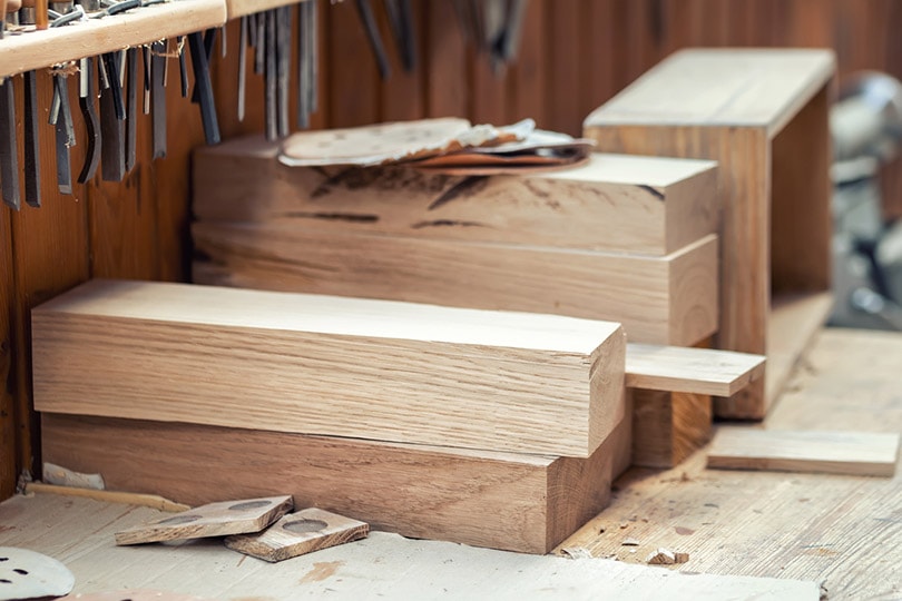 bloques de madera de roble apilados en el taller de carpintería con herramientas